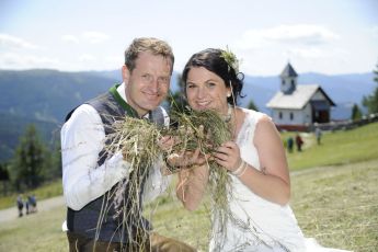 Hochzeitsfoto vom Brautpaar im Sommer auf Bergwiese