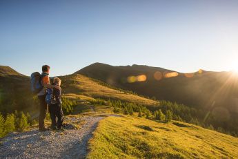 Zwei Wanderer genießen den Sonnenuntergang in den Bergen von Kärnten
