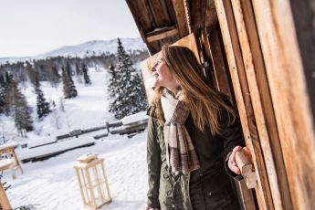 Frau bei einer Berghütte im Winter am Katschberg