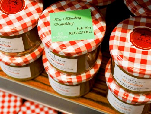 Mehrere Gläser Lärchenhof Marmelade mit rot-weiß karierten Deckeln, mit einem grünen Etikett, das "Der Klimaberg Katschberg, Ich bin REGIONAL!" zeigt