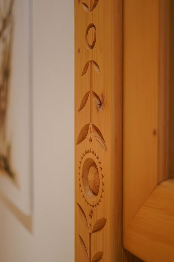 Eine detaillierte Holzschnitzerei an einem Türrahmen im Hotel Lärchenhof