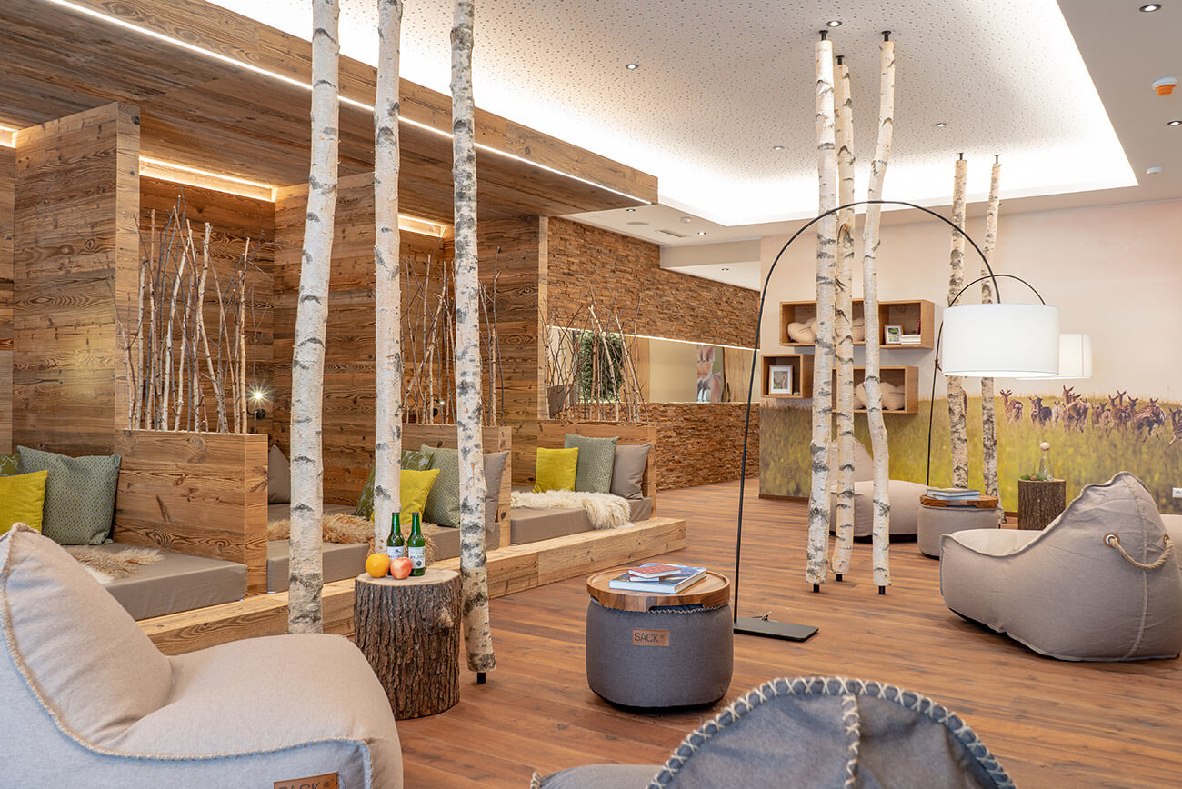 Ein gemütlicher Wellnessbereich im Hotel Lärchenhof mit Sitzsäcken, Birkenstämmen und beruhigender Atmosphäre