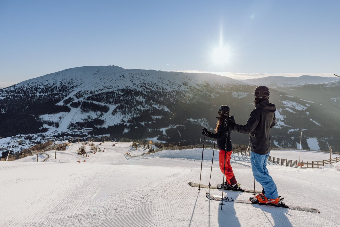 Skipiste im Sonnenschein mit Skifahrern
