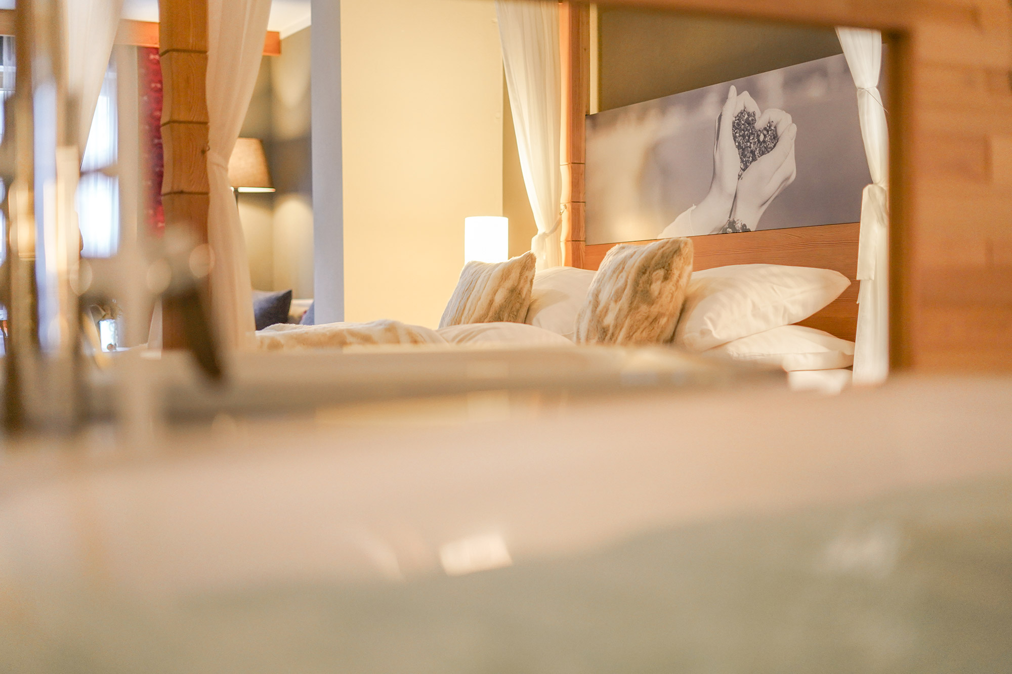 Ein gemütliches Hotelzimmer im Hotel Lärchenhof mit einem großen Bett und dekorativen Kissen